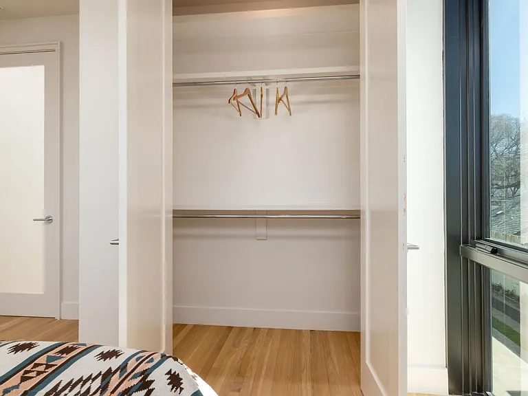 Bedroom 2 features a queen bed and windows on two sides, with room-darkening shades for restful sleep and added privacy.