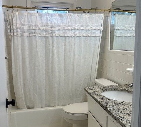 Bathroom with a weather shielded window and large sink area.