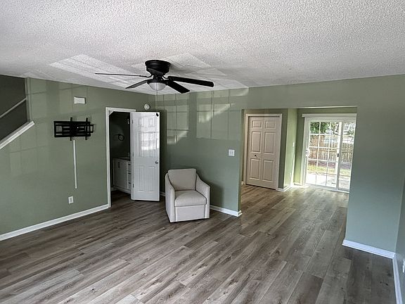 entry living room from different angle, showing downstairs 1/2 bath and entry to dining/kitchen area on the right.