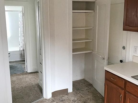 Handy pantry closet and hallway leading to bathroom