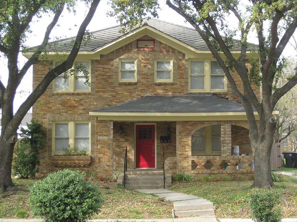 Huge, healthy oak trees frame the front of the house.