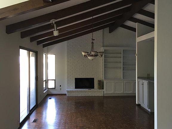 From living room: dining area, fireplace, shelves & cabinets, and upper balcony access.