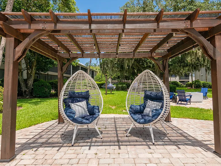 Immerse yourself in plush, modern seating beneath the pergola's tranquility.