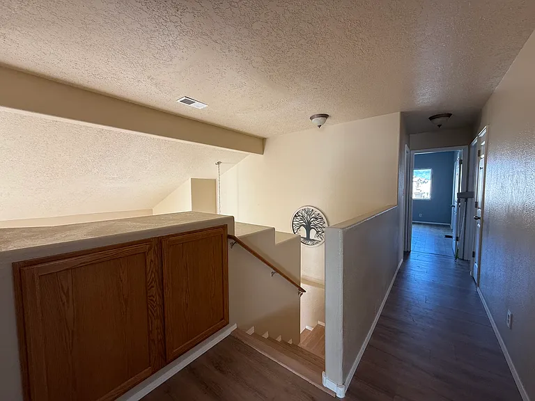 Upstairs hallway leading to the stairs, 2 bedrooms, and a bathroom