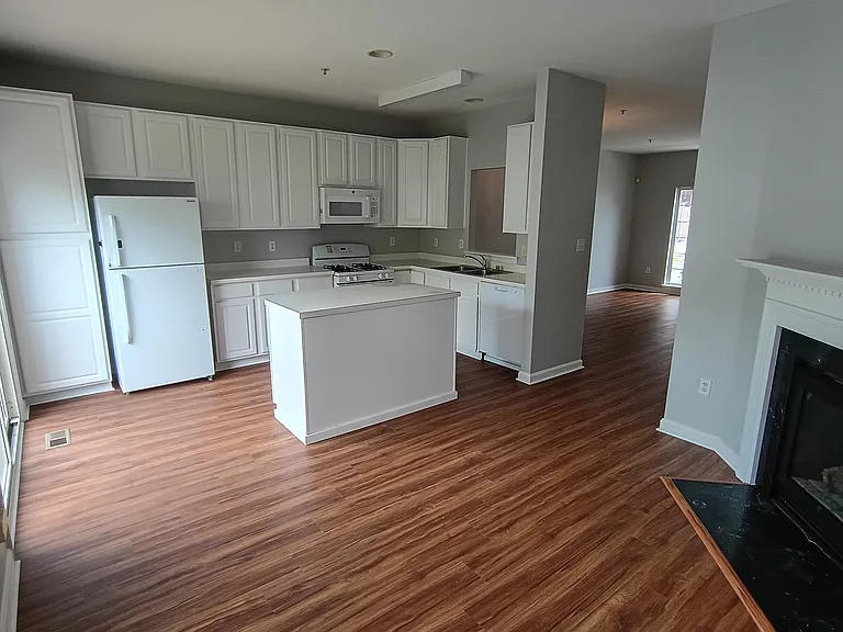 Kitchen area with island new paint and flooring. new dishwasher, and microwave
