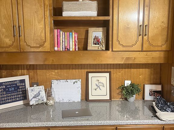 Study with LED lighting, overhead desk lighting, custom cabinets, and plenty of storage space for work and personal with built-in shelves on top and bottom.