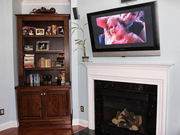 TV wall mount included (65" TV pictured). Coat closet just off-frame to the right
