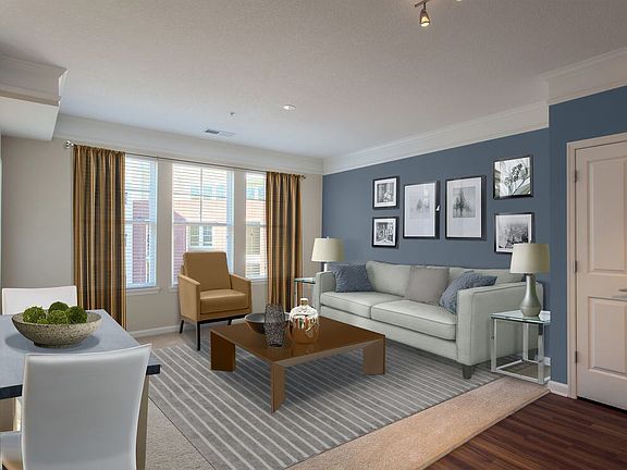 Carpeted living and dining area with accent wall