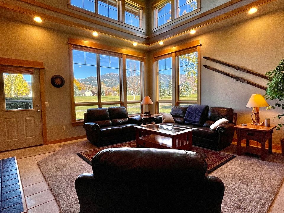 The living room with large windows and mountain views.