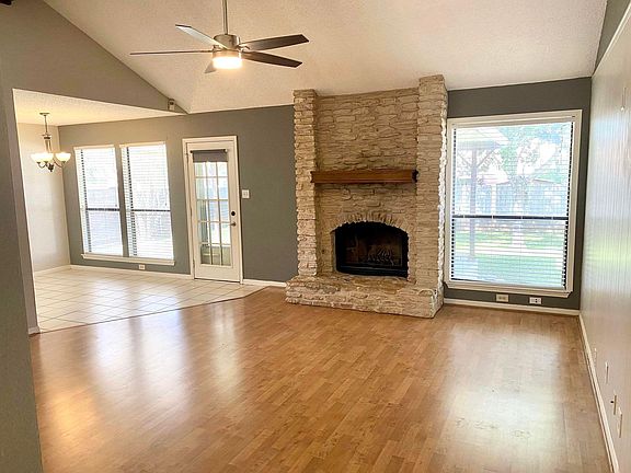 Step into the inviting living room, adorned with a vaulted ceiling that opens up the space. The centerpiece of this charming room is a cozy wood-burning fireplace, exuding warmth and providing the perfect focal point for gatherings and relaxation. Drawing