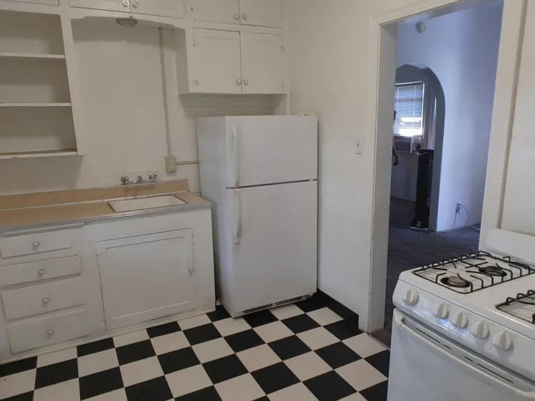 Kitchen looks on small back yard and has full-sized gas range and fridge.