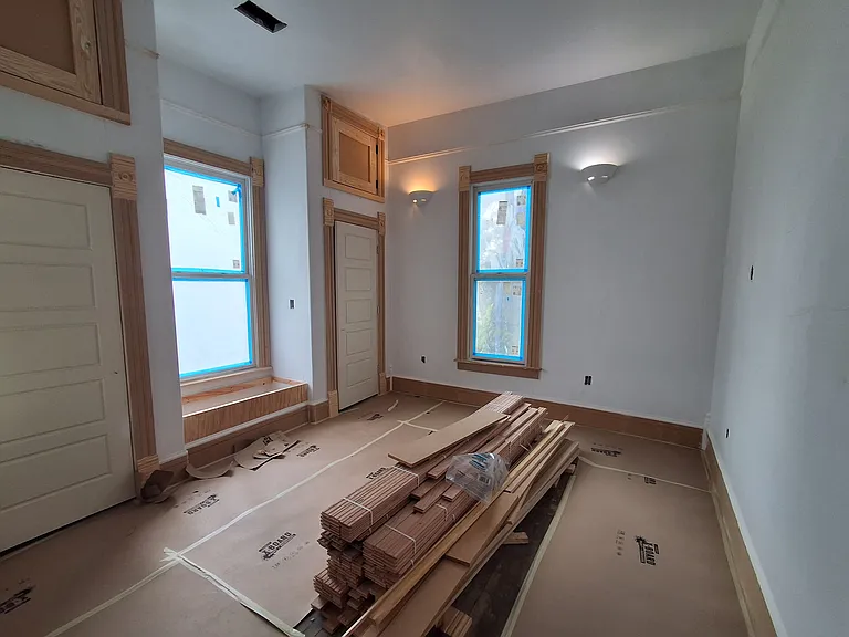 Charming bedroom or office with window seat - 11 foot high ceilings, two closets, windows on three sides, just off living room. Original hardwood floors will be restored.
