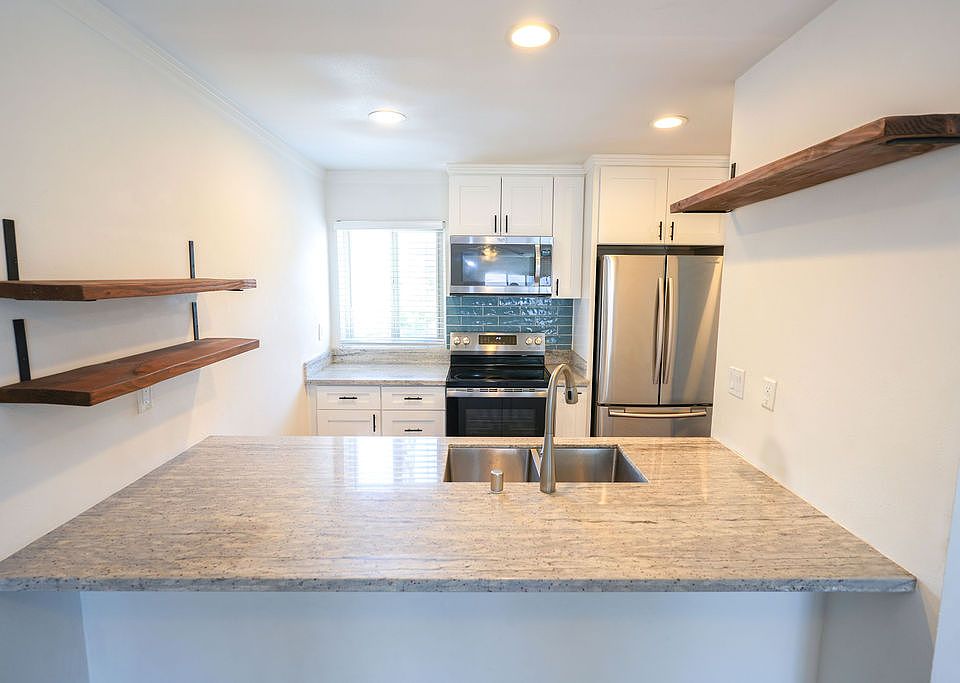 Open concept kitchen with granite countertop and stainless steel appliances