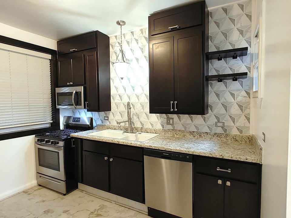 Kitchen with stainless steel appliances. (Angle is funny, but that is a wider-than-normal window.)