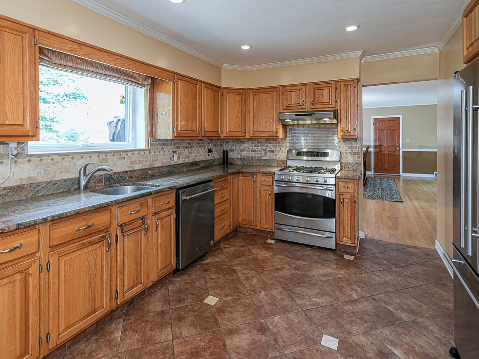 Spacious kitchen with beautiful view overlooking the backyard over the sink. Kitchen is adjacent to the dining area as seen through the doorway to the right of stove.