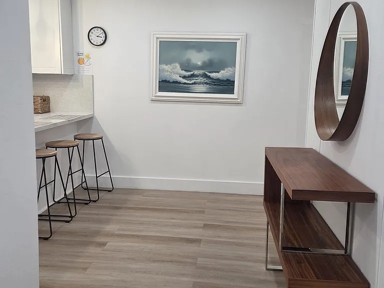 Open common area with breakfast bar seating, ample cabinetry, and an entry console with mirror for everyday convenience.
