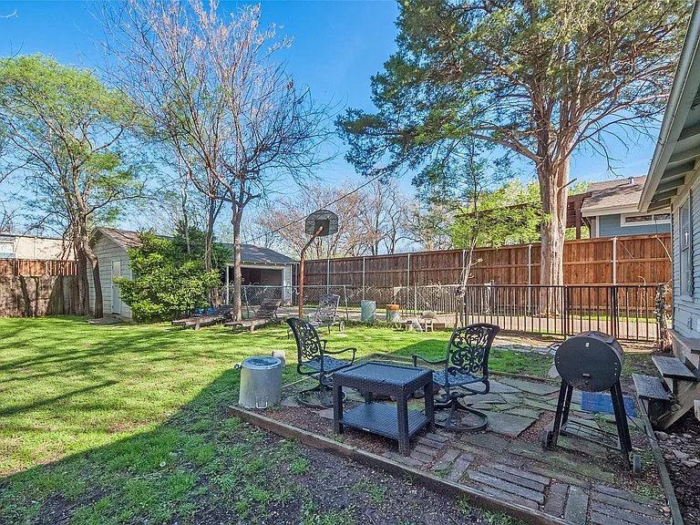 A cozy backyard with a patio area and a grill, perfect for outdoor cooking and relaxation.