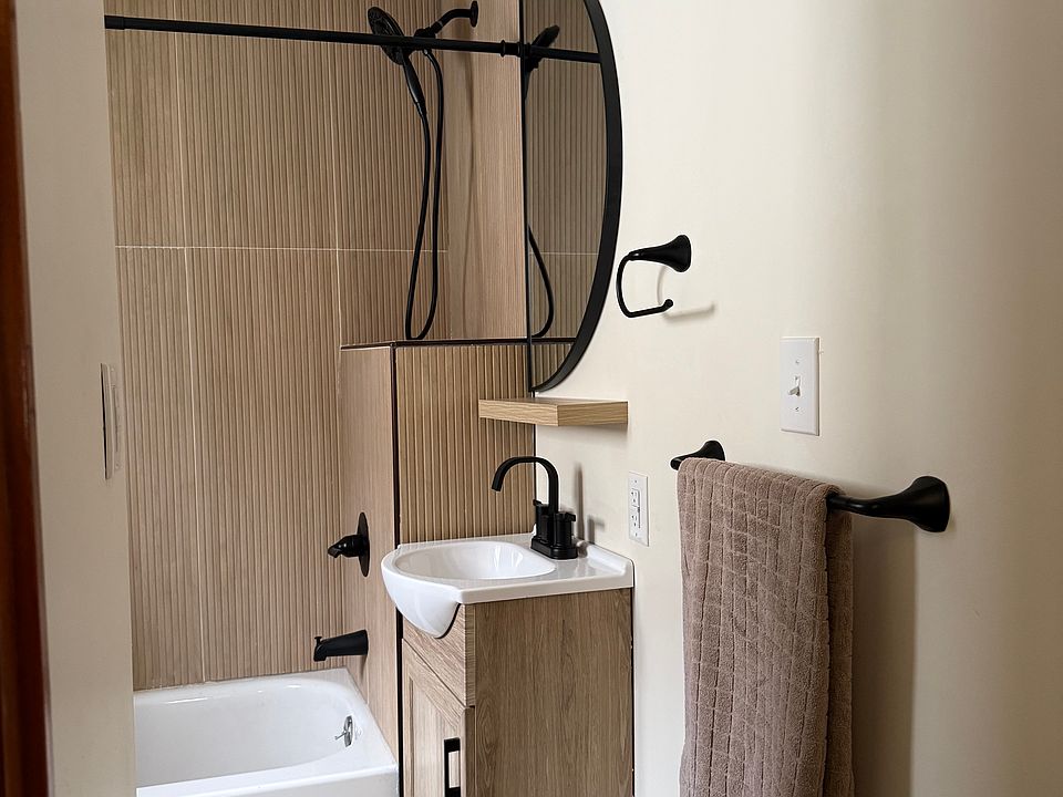 Sunlight from the window enhances the vertical wood-grain tile, adding warmth and dimension throughout the bathroom.