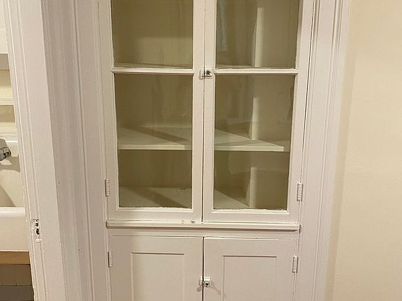 MAIN LIVING ROOM Detail of glass display cabinet and wooden cupboard