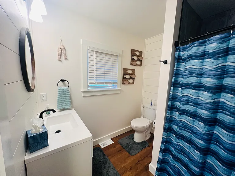 Newly renovated bathroom with large tub/shower, vanity with storage, and linen closet.