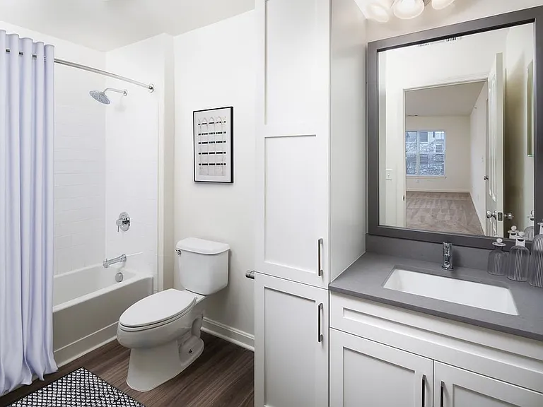 Bath with gray quartz countertops, hard-surface flooring, and upgraded fixtures
