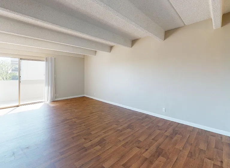Bright living space with floor to ceiling windows and balcony access