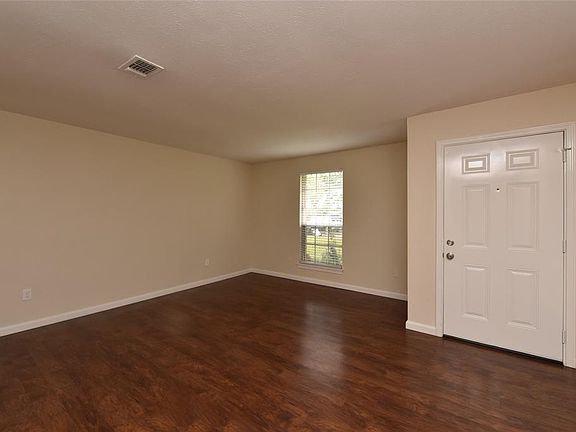 Entry into the formal living or dining area with wood like floors and fresh paint.