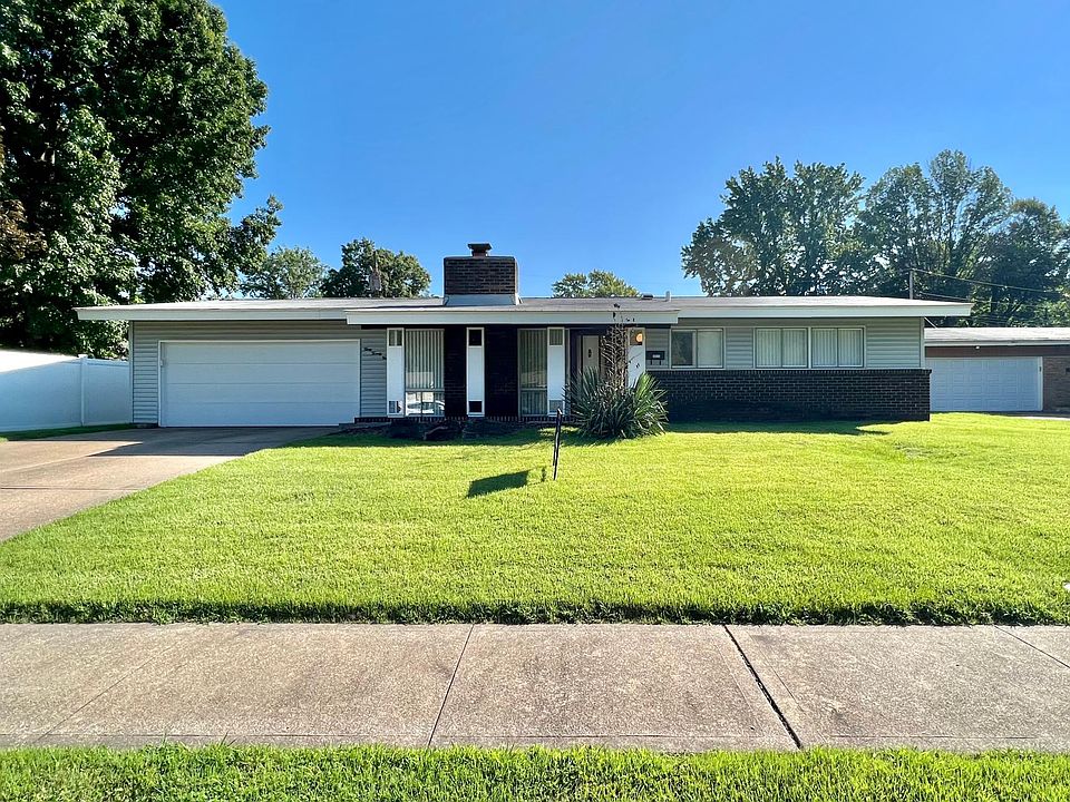 Front of the house with a well manicured yard and sidewalks in the subdivision