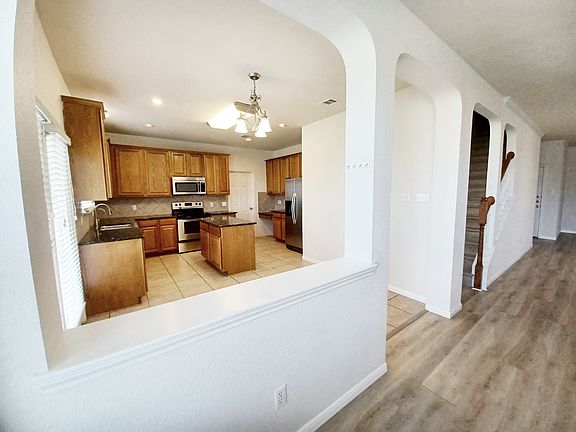 Open-concept kitchen with abundant cabinet storage, walk-in pantry, and stainless steel appliance.