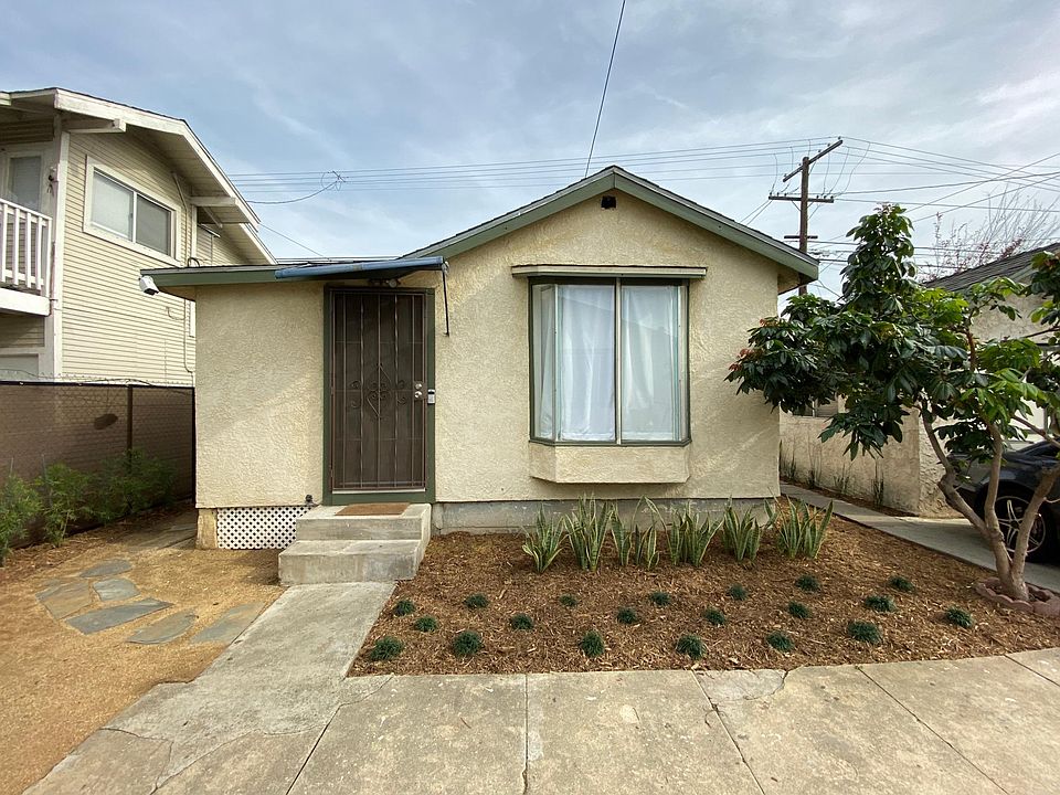 Front entrance with side gate to outdoor laundry to the left and one driveway parking on the right..