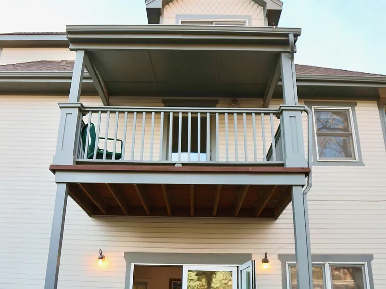 Back of the house with panoramic door and back porch with grill. Top porch is sitting area off of the primary bedroom.