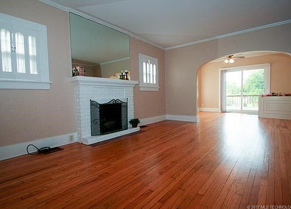 Living Room w/ gleaming original hardwood floors, gas fireplace and  new neutral paint.
