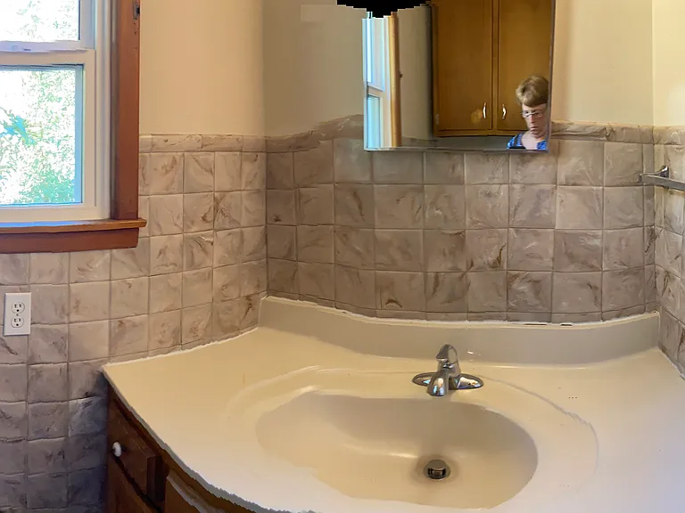 Bathroom with flow to laundry area and kitchen.
