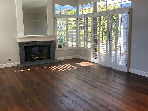 View looking into family room with gas fireplace, plantation shutters.