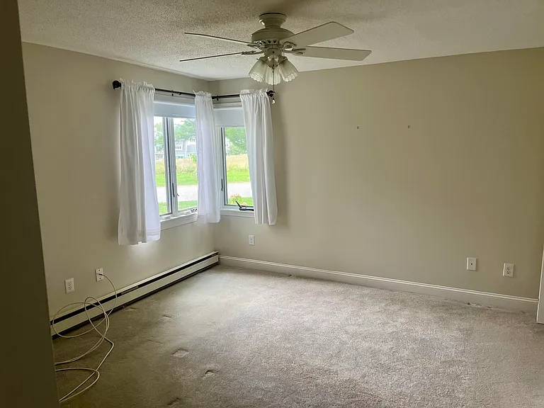 Bedroom #1, with corner windows looking out at the wild meadow