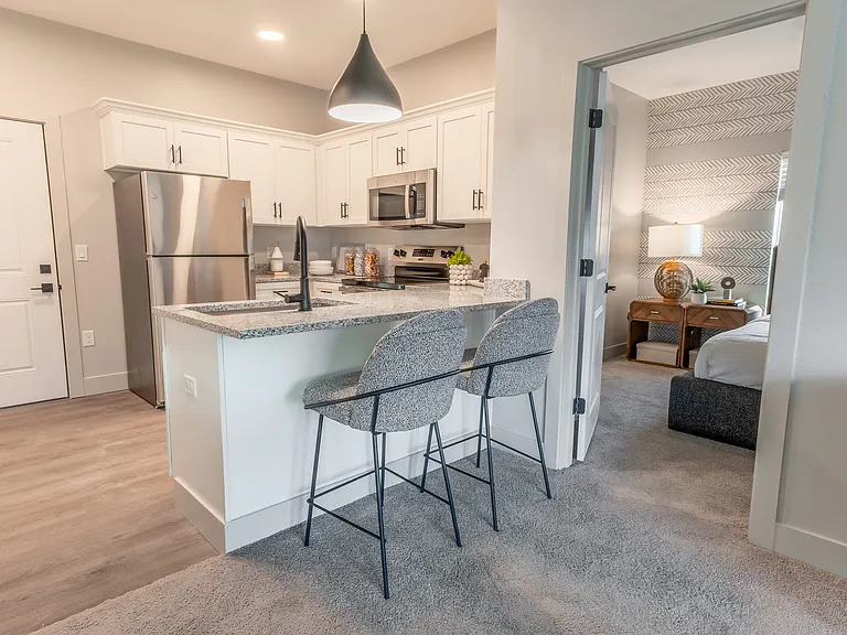 Step into sleek sophistication with this stylish apartment kitchen, perfect for culinary creations and cozy dining.