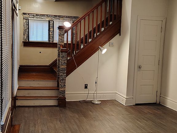 Living room showing stairway and coat closet under stairway.