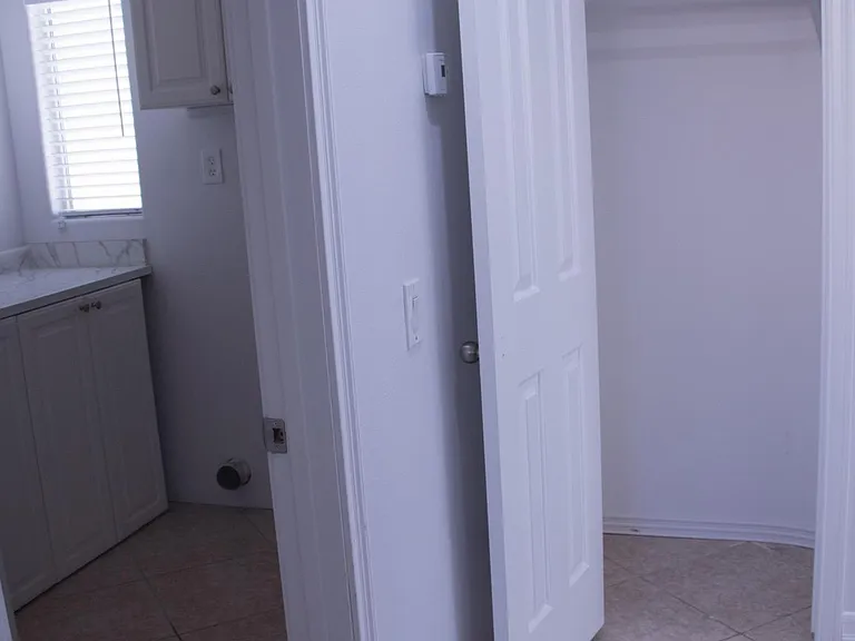 Downstairs hallway coat closet in front of the full bathroom and next to the laundry room