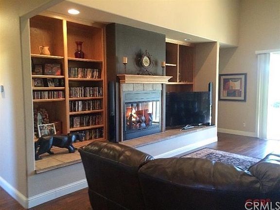 The great room has wide wood plank floors land overlooks a large covered patio