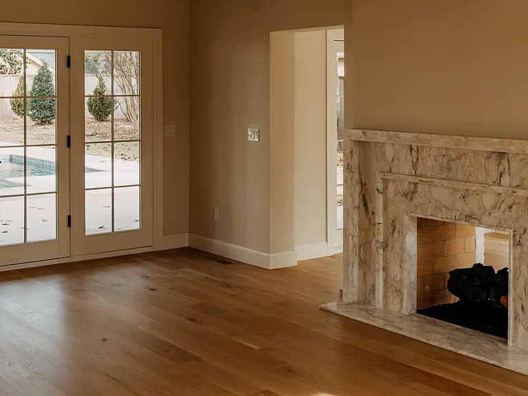 Living room with views and glass doors to pool area. 2- sided gas fireplace