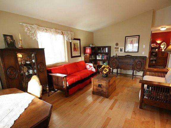 Light filled living room with wood floors and vaulted ceiling.
