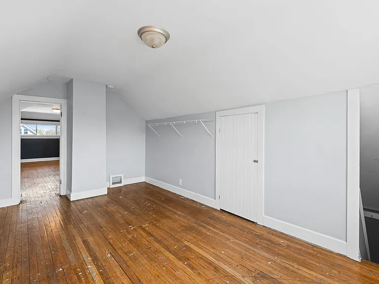 This is the smaller room on the third floor, second level of the unit. It has some closet racking and shows the storage area, as well as the steps that lead down to the back entrance of the unit.
