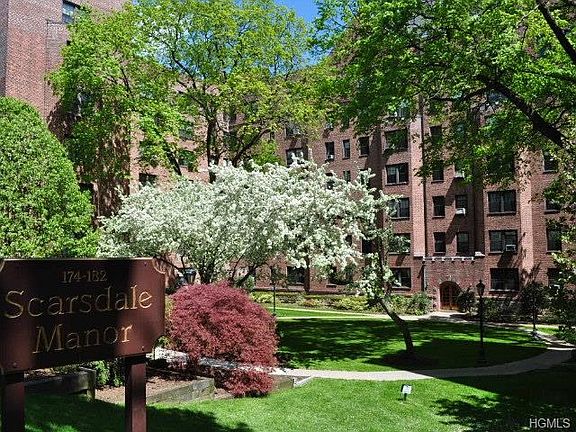 The living room has treetop views and overlooks the quiet courtyard. There are two arched opening, o