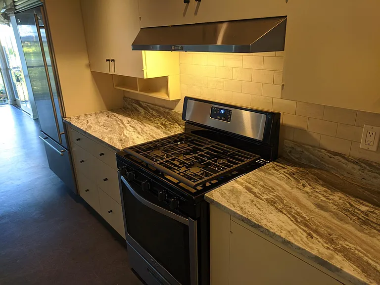 Newer gas stove 2 speed fan vented to the outside, extensive custom storage cabinetry.