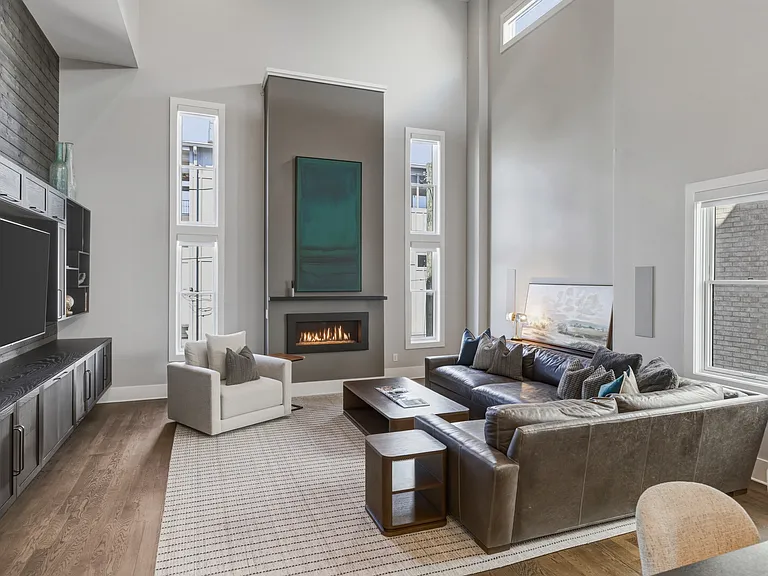 Bright, modern living room with HUGE ceilings. Abundant natural light, plush seating for everyone, a cozy gas fireplace, and a Smart TV_perfect for relaxing.
