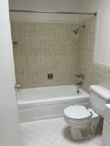 Tiled bathroom with full tub and vanity,
