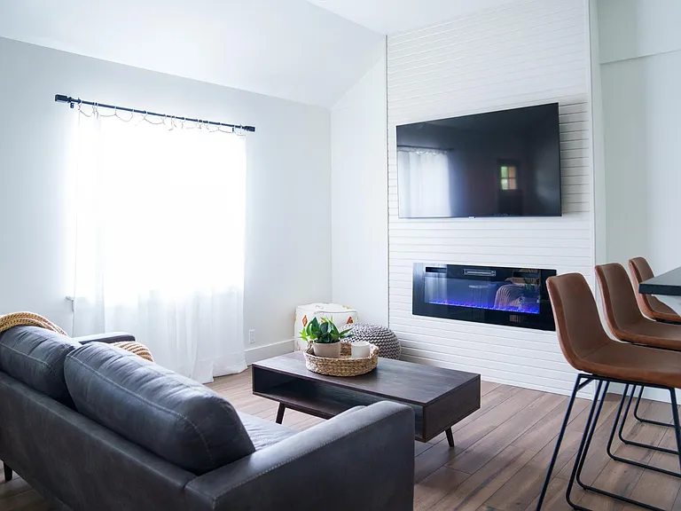 TV and electric fireplace mounted on accent wall from reclaimed wood