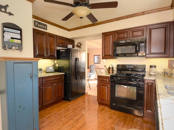 Warm, Rich Pergo Flooring, Crown Moulding, and Ceiling Fan