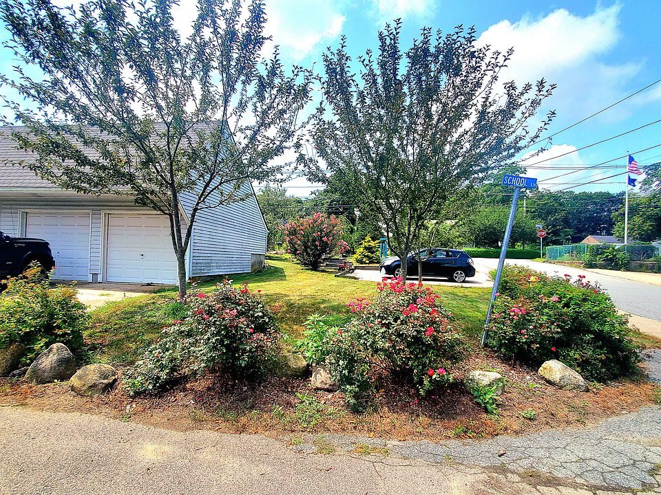 View of garden and parking garage adjacent to apartment.