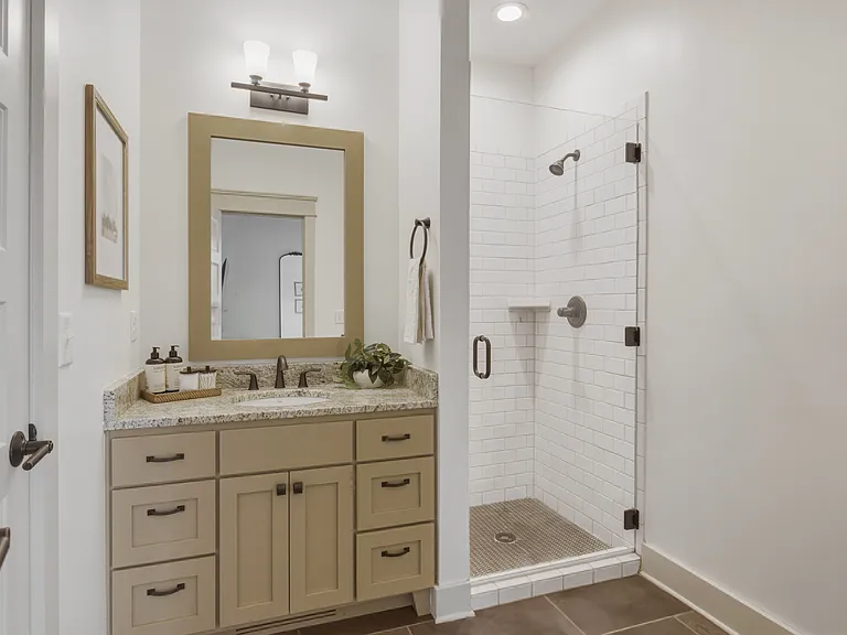 Bathroom 2 includes a vanity with storage for toiletries, and a standing tiled shower.